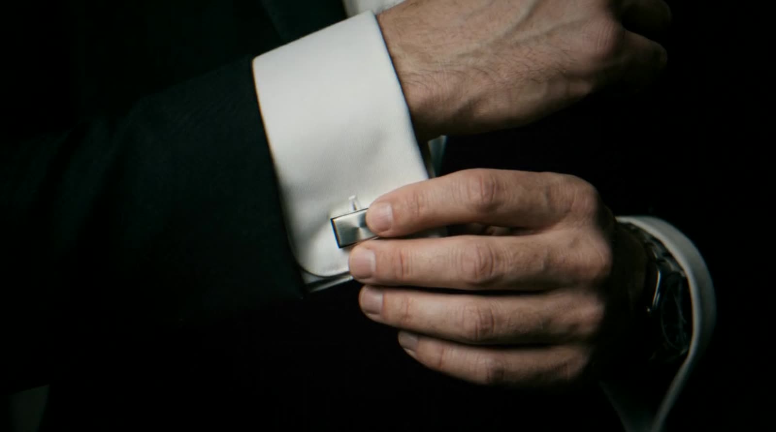 R5 chauffeur fastening a cufflink on the morning of the wedding
