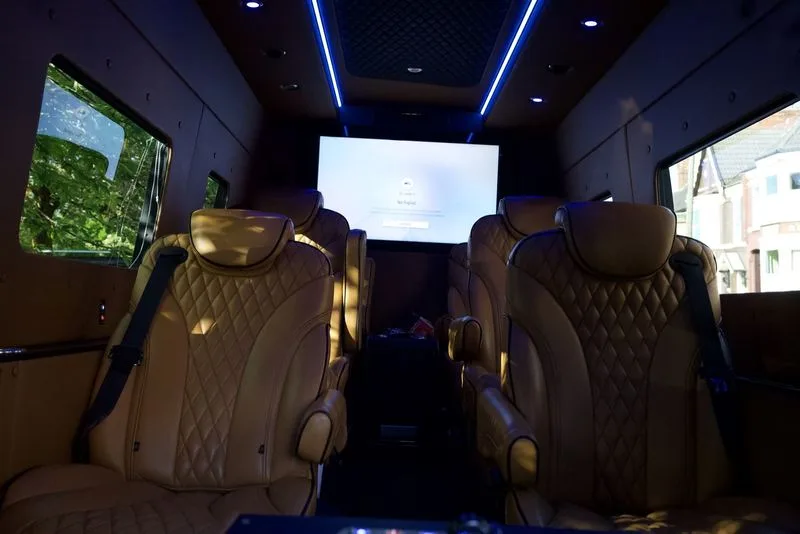 Tan quilted captain seats inside an R5 Sprinter, with light strips and a screen on the bulkhead