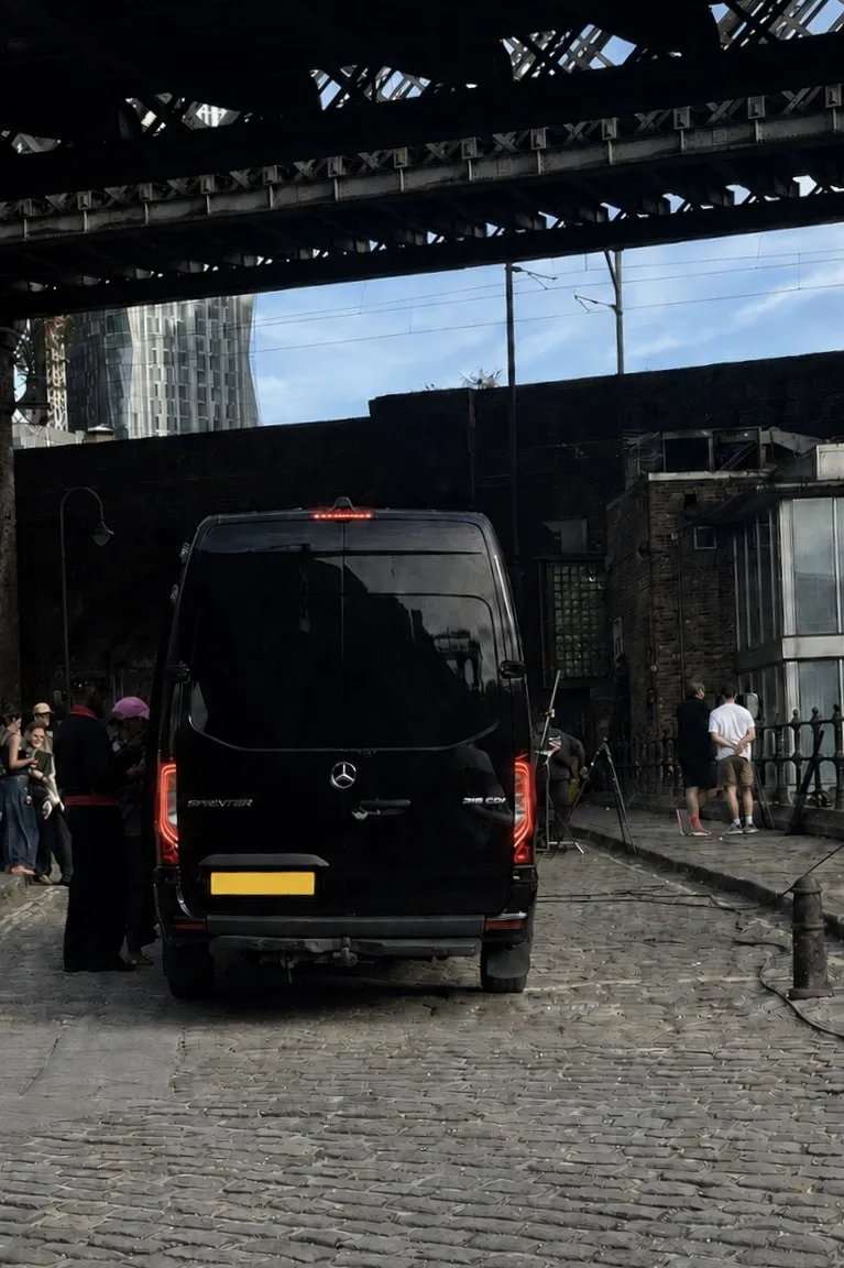 An R5 Mercedes Sprinter at a Manchester location on the cobbles beneath a railway viaduct, with crew and kit alongside